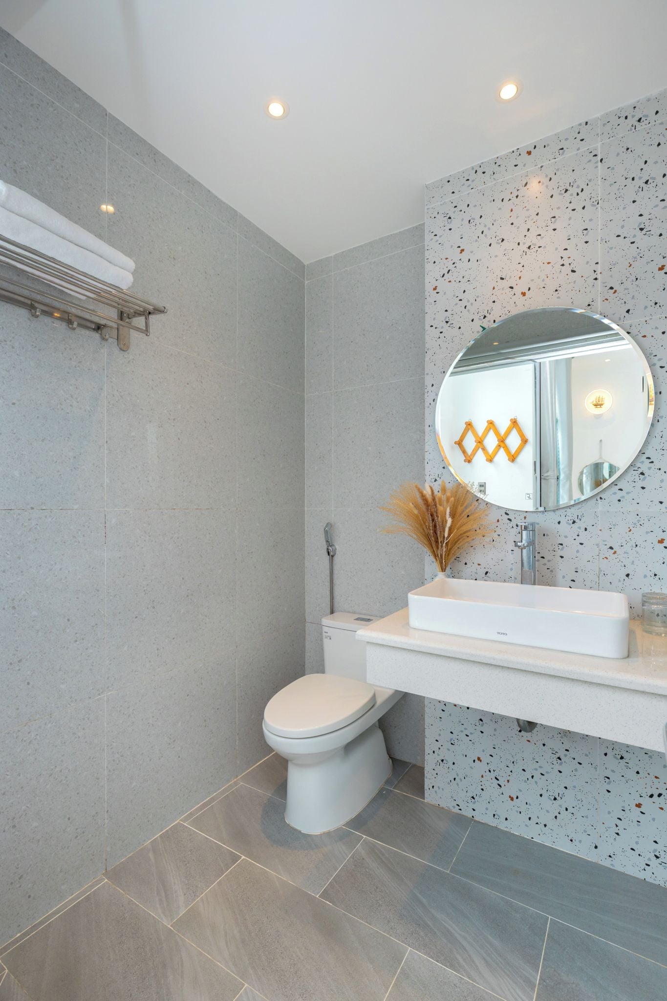 Ein modernes Badezimmer mit Toilette, Waschbecken und Spiegel.