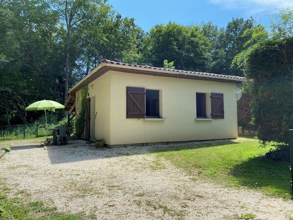 Un petit bâtiment d’un seul étage, doté d’un toit en tuiles et de deux fenêtres avec volets.
