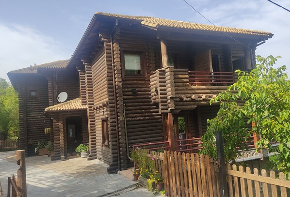 A log cabin with a balcony, a satellite dish, and potted plants. - Yliessa Chalet (Karpenisi)