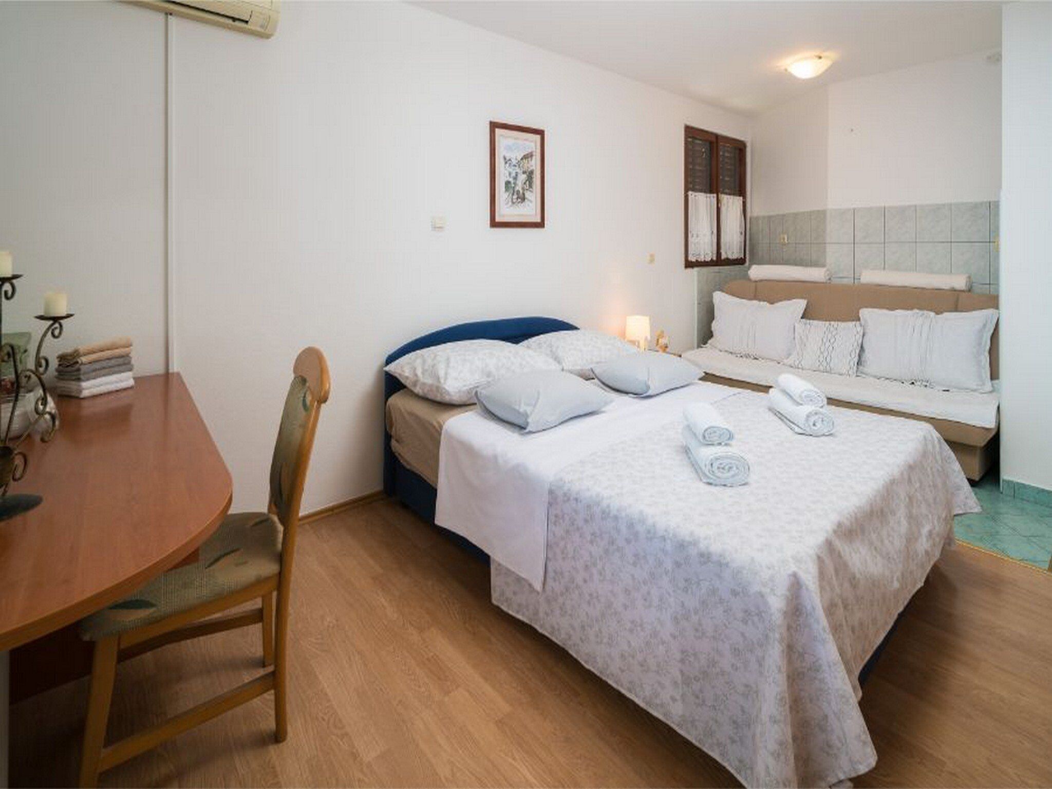 Ein Hotelzimmer mit Bett, einer Couch, einem Esstisch und einem Stuhl.
