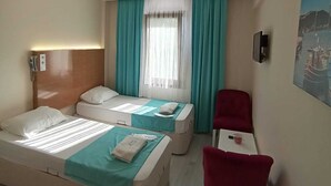 Habitación de hotel con dos camas, un escritorio y una silla.