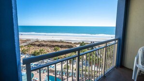A balcony with a view of the beach and a pool area. - New Floor Private Balcony Oceanfront Decor with Pools (North Myrtle Beach)