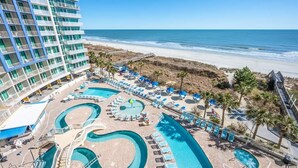 A hotel with multiple swimming pools, a beach view, and a large building with balconies. - New Floor Private Balcony Oceanfront Decor with Pools (North Myrtle Beach)
