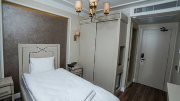 Ein Hotelzimmer mit einem großen Bett, Nachttischen, einem Kleiderschrank und einer Deckenleuchte.