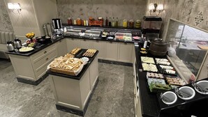 A buffet setup with various food items and condiments.