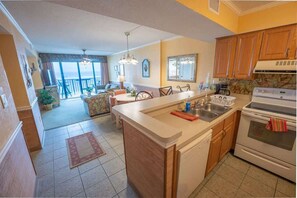 Een koelkast met diepvriezer, een microgolfoven, een oven, een kookplaat