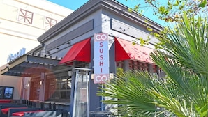 Un ristorante sushi con una tenda rossa e un cartello che riporta la scritta 'SUSHI'.