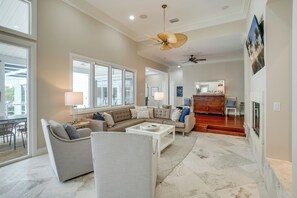 A spacious living room with a large sectional sofa, a coffee table, and a ceiling fan.