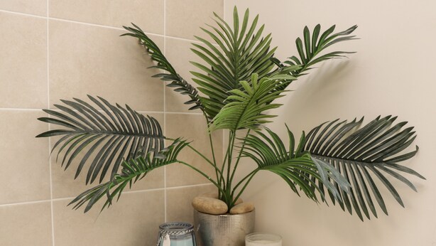 A bathroom with a potted plant, a blue vase, and a candle on a tiled shelf. - Woodside View (Whitby)