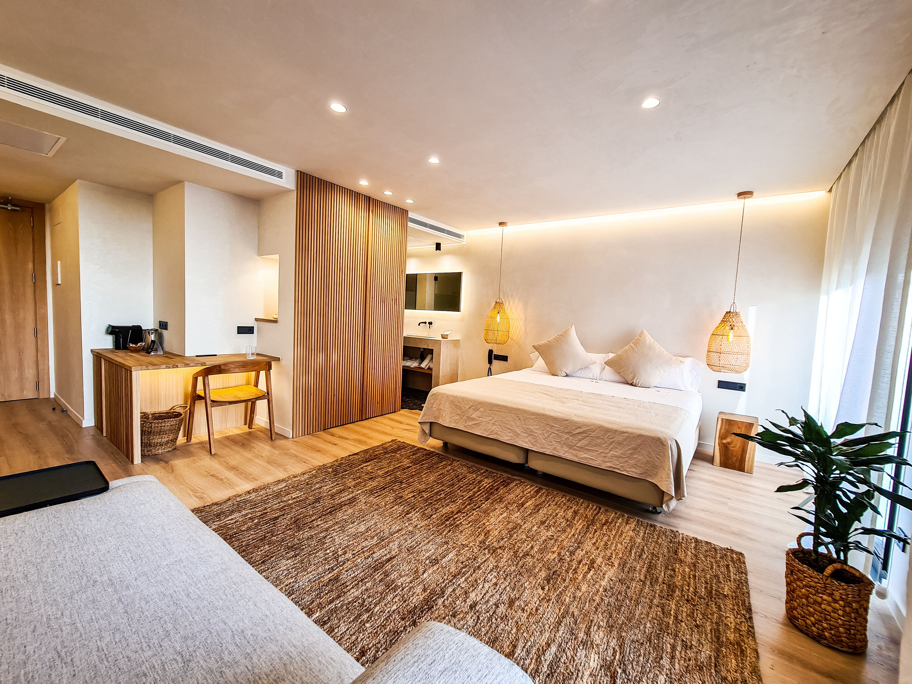 Een moderne hotelkamer met een groot bed, een bureau en een zithoek.