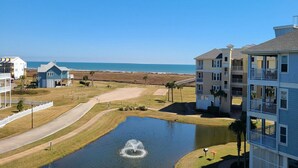 Um hotel à beira-mar com edifícios de vários andares, piscina e vista para o oceano.
