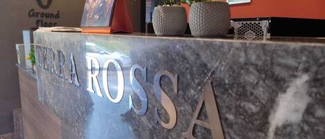 A reception desk with the name "TERRA ROSSA" in large letters.