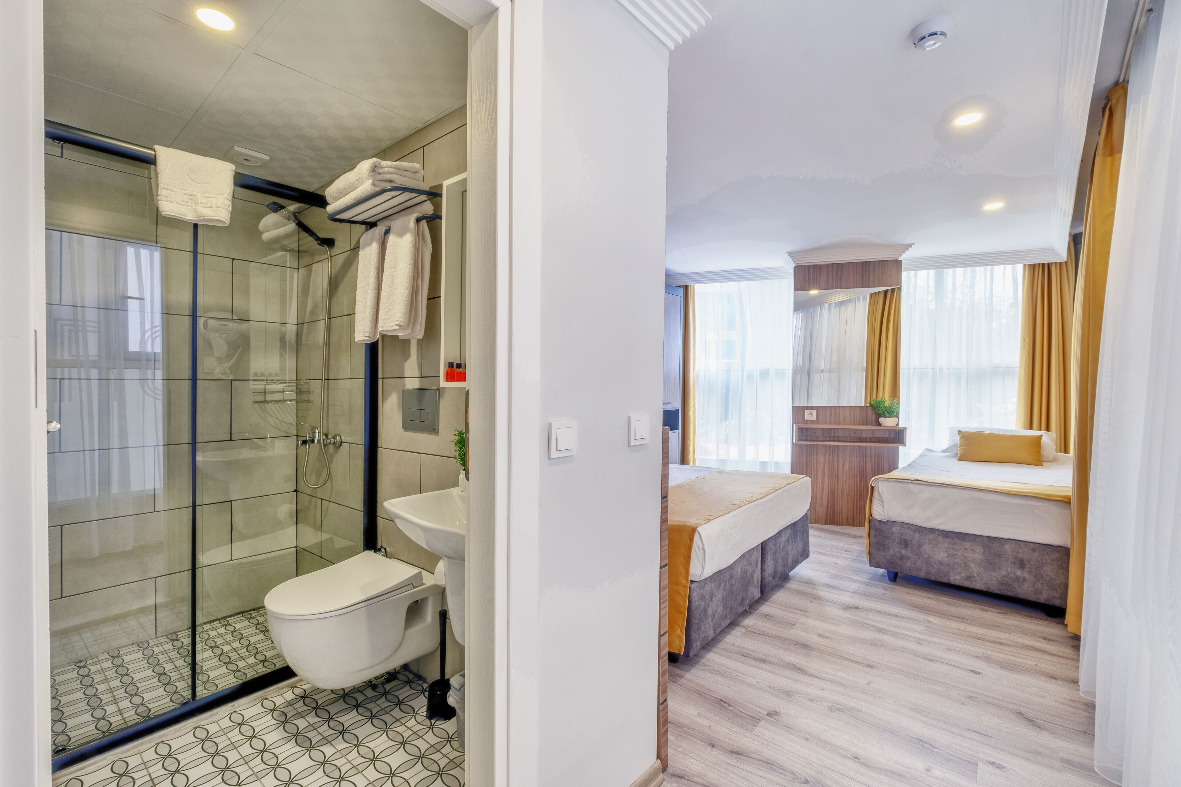 Uma casa de banho moderna com cabine de duche em vidro, sanita e lavatório.