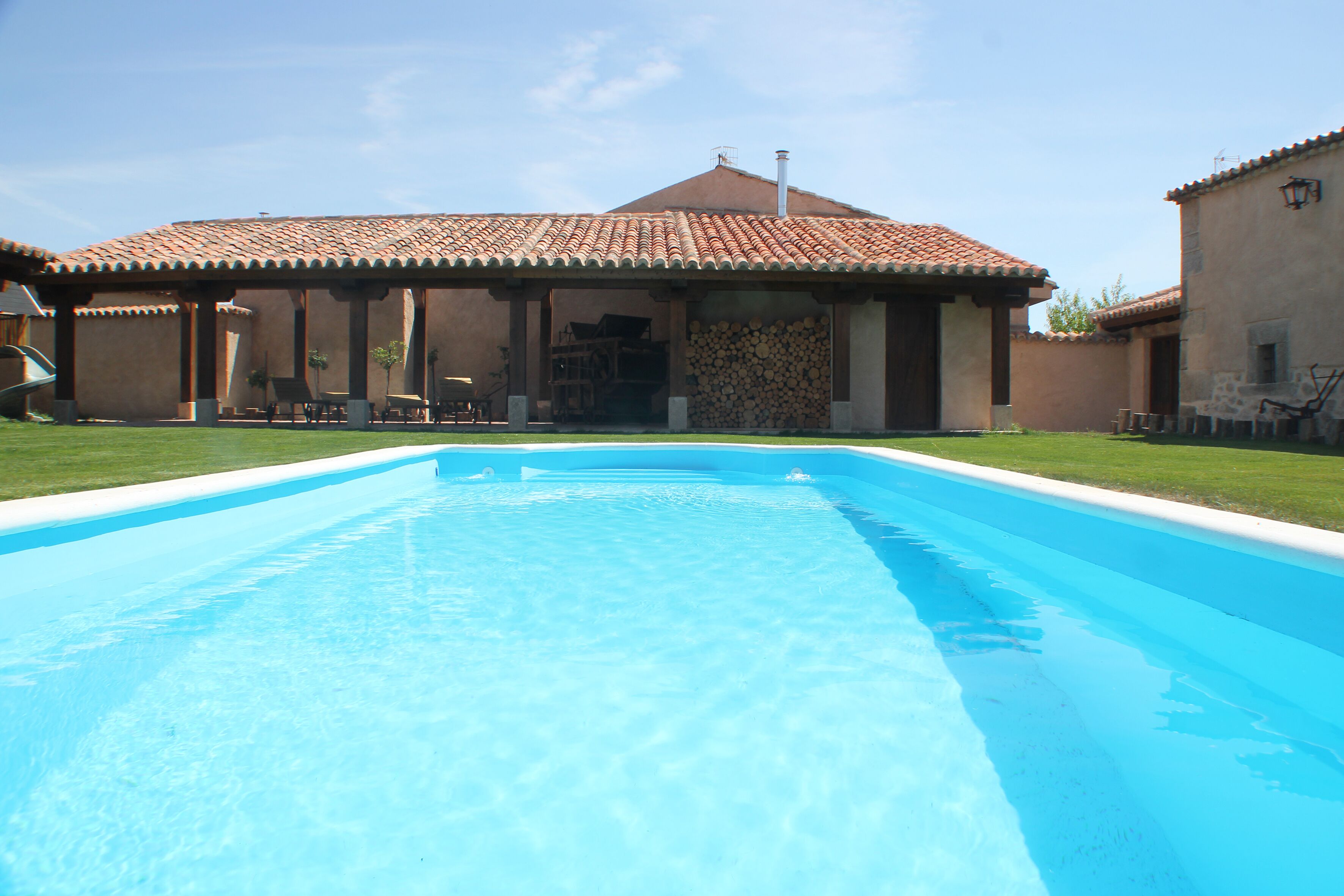Una piscina al aire libre, tumbonas