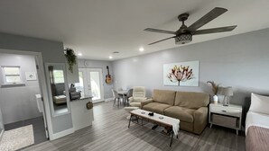 Ein modernes Wohnzimmer mit einer Couch, einem Couchtisch und einem Deckenventilator.