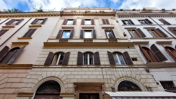 A multi-story building with a classic architectural style, featuring arched windows and a central entrance with a door marked 'OK'. - Luxury apartment in Rione Monti (Roma)