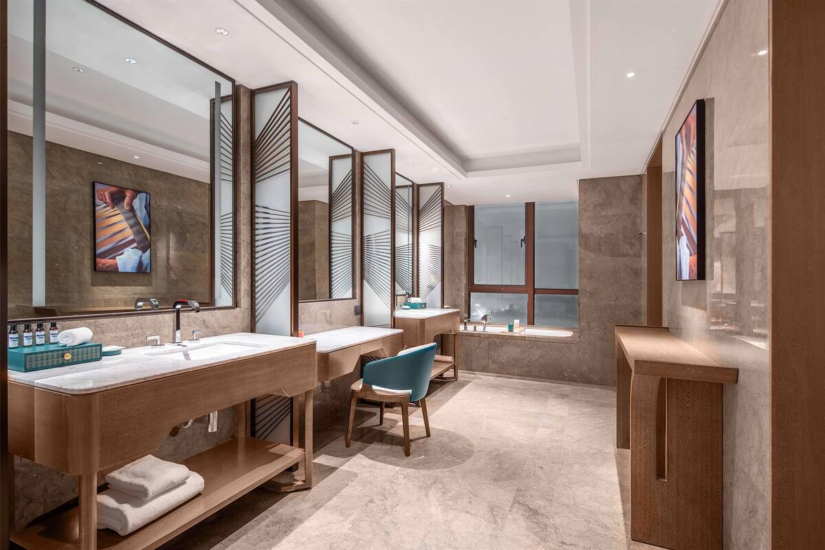 Une salle de bain moderne avec deux lavabos, un miroir et une fenêtre.