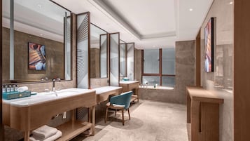 Un baño moderno con tres lavamanos, un espejo grande y un tocador con una silla.