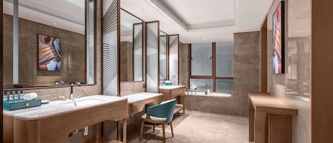 A modern bathroom with three sinks, a large mirror, and a vanity with a chair.