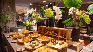 Une vitrine de boulangerie présentant diverses pâtisseries et une composition florale décorative.