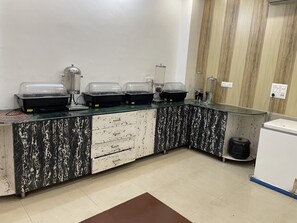 Un espace cuisine doté de plans de travail en marbre, d’un évier et d’un réfrigérateur.