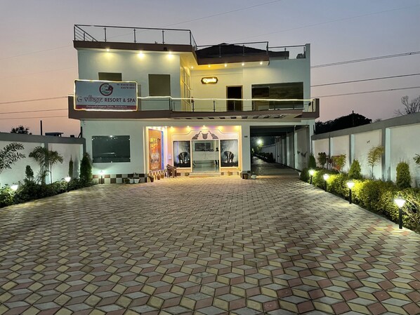 Un bâtiment à deux étages avec une enseigne indiquant « G Village Resort & Spa ».
