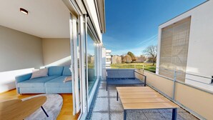 A modern balcony with a sofa, a small table, and a wooden bench. - Chic apartment - Überlingen on Lake Constance (Überlingen)