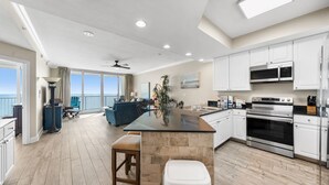 A spacious kitchen with a central island, white cabinetry, and stainless steel appliances.