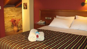 Ein Hotelzimmer mit einem Bett, einem Nachttisch, einem Telefon und einer Vase mit Trockenpflanzen.