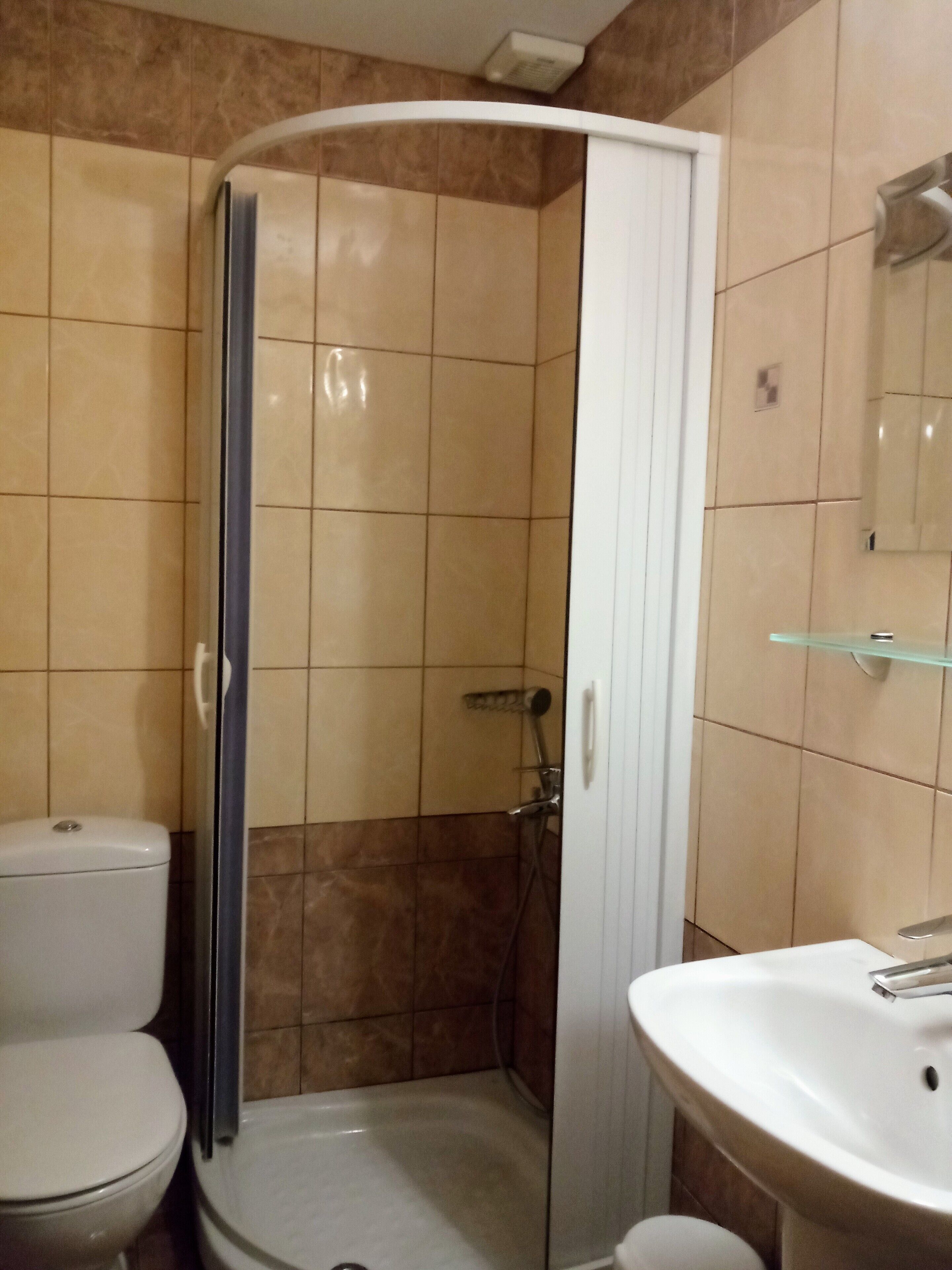 Un baño con ducha, inodoro y lavamanos.