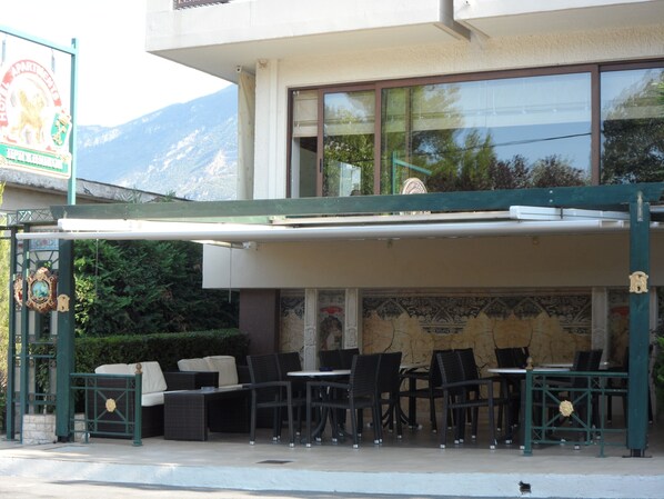An outdoor seating area with wicker furniture and a covered patio.