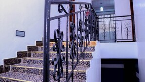 A staircase with ornate black metal railings and patterned stone steps. - Delight Mainstay Homes by Della (Nairobi)