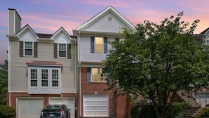 A two-story house with a garage, a car parked in front, and a tree in the yard. - Finchwood: Private Yard & Near DC (Sterling)