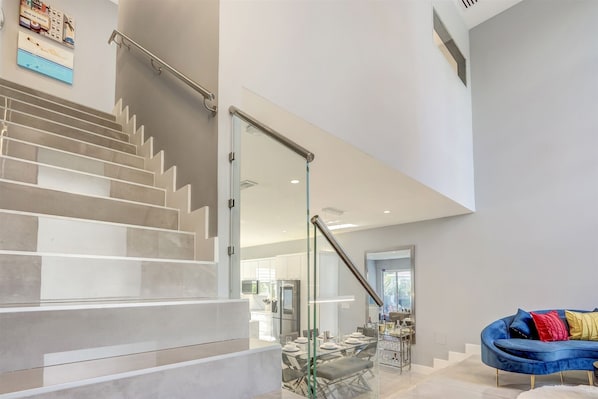 A modern interior with a staircase leading to a dining area.