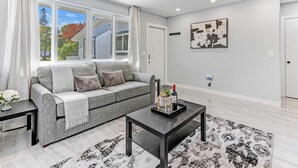 A modern living room with a grey sofa, a coffee table, and a patterned rug. - Hallandale 1037 | Lakeside View: 15KM to Stadium & Near Beach (Hallandale Beach)