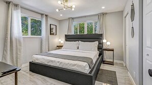 A modern bedroom with a large bed, bedside tables, and a ceiling light fixture. - Hallandale 1037 | Lakeside View: 15KM to Stadium & Near Beach (Hallandale Beach)