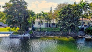 A house with a stone wall and a small pond in front. - Hallandale 1037 | Lakeside View: 15KM to Stadium & Near Beach (Hallandale Beach)