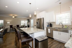 Enjoy cooking in the well-equipped kitchen with a central island, bar stools, and ample counter space.
