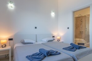 A hotel room with two beds, a shower area, and wall-mounted lights. - A magical view of the sea, a magical villa (Labin)