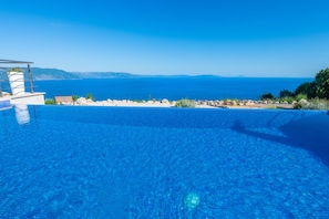 A clear blue infinity pool with a view of the sea and distant mountains. - A magical view of the sea, a magical villa (Labin)