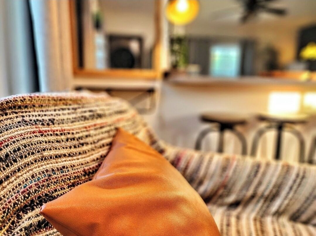 Un canapé recouvert d’un tissu à rayures et doté d’un coussin marron.