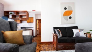 A modern living room with a sofa, a coffee table, and a kitchen in the background. - Delight Homes by Della (Nairobi)