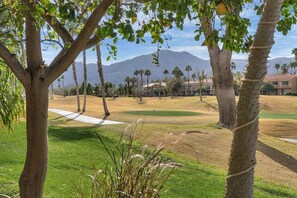 A golf course with a clear view of a mountain range in the background.