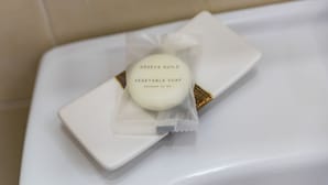 Een witte zeepstaaf met een etiket waarop staat 'GENEVA GUILD VEGETABLE SOAP' op een witte ondergrond.