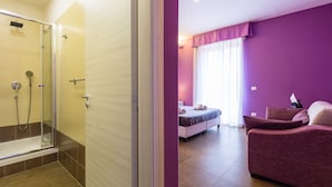 Een moderne badkamer met een douchecabine van glas en een apart toiletgedeelte.