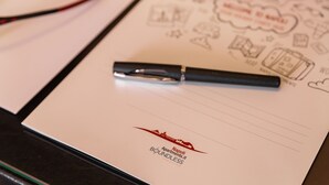 Una libreta con un bolígrafo, mostrando un logotipo y texto para 'Napoli Boundless Apartments'.