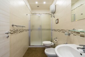 Een douche, een haardroger, een bidet, handdoeken