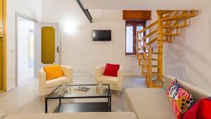 A modern living room with a sofa, armchairs, a coffee table, and a staircase. - CasaNa on Christmas Alley (Napoli)