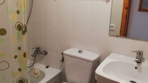 A bathroom with a toilet, a sink, and a shower.