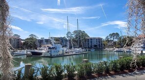 A marina with boats docked, surrounded by buildings and greenery.